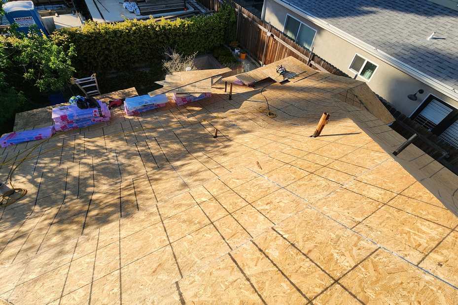 Daylight view of an exposed wood roof deck marked with layout lines.