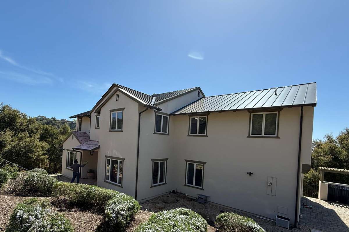 Daylight view of a completed home exterior with finished metal rooflines.