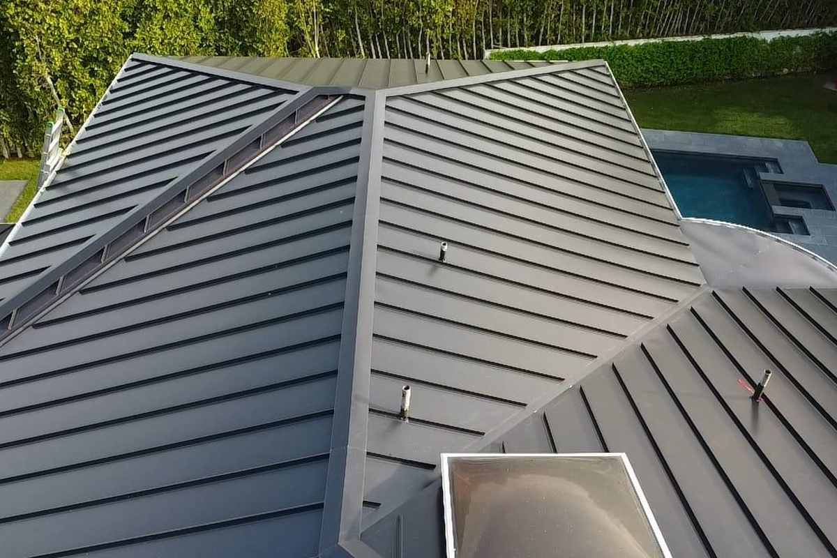 Daylight view of finished standing-seam metal roof planes viewed from above.