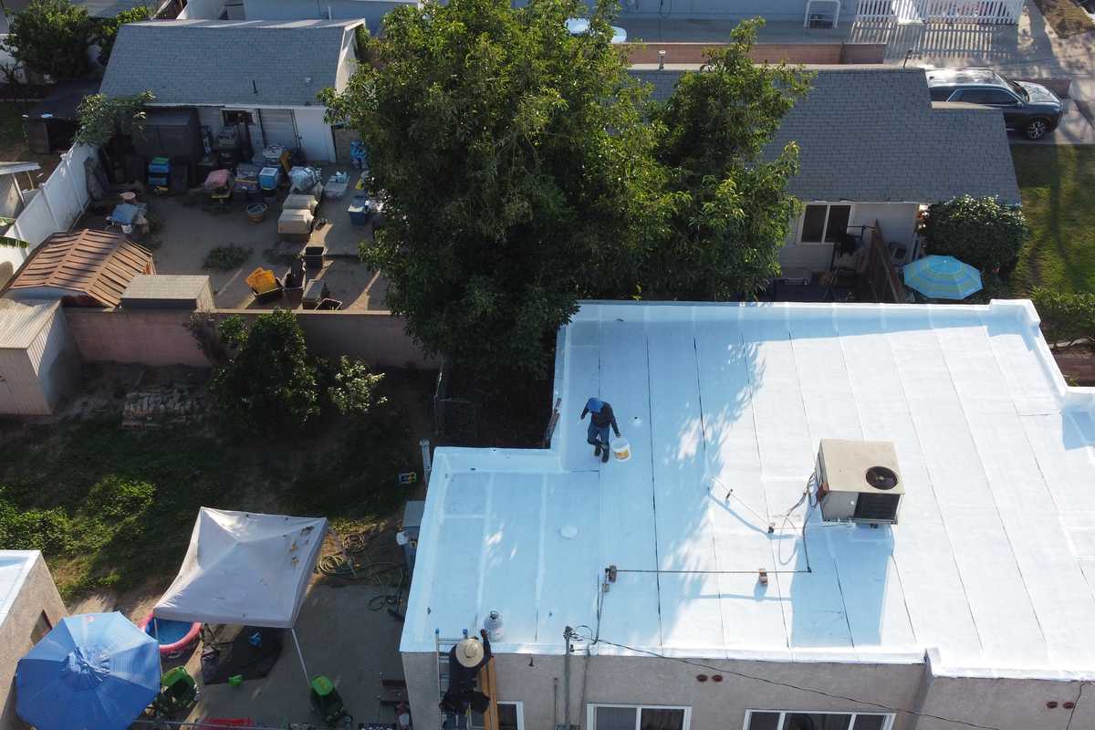 Roof-level photograph showing a white low-slope roof with several penetrations.