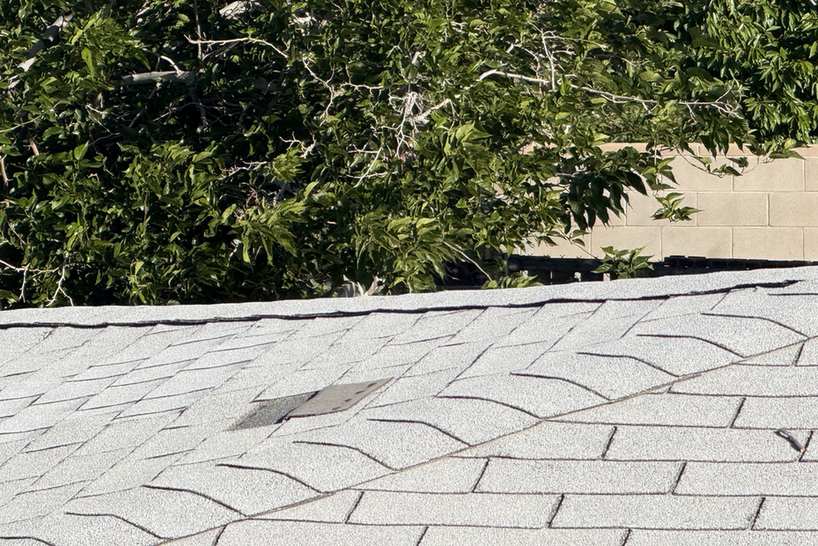 Elevated view across a close roof-level view of worn shingle surfaces.