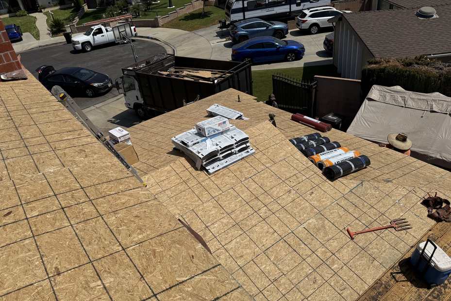 Daylight view of a broad exposed roof deck during replacement work.